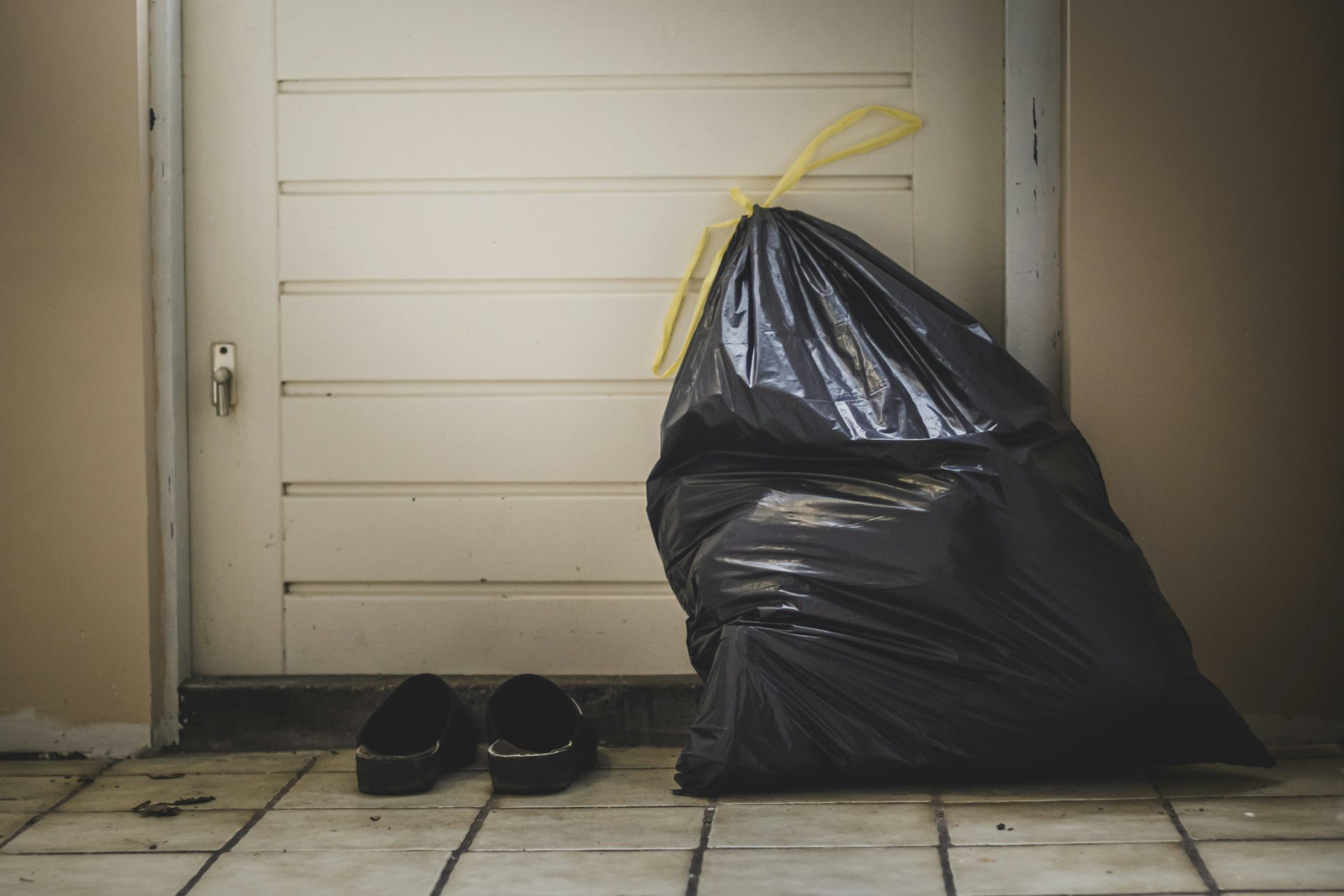 black plastic bag beside white wall